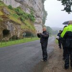 Les motards au bord de la route sous la falaise