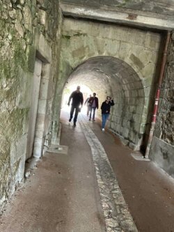 Piétons dans ruelle couverte à Laroquebrou
